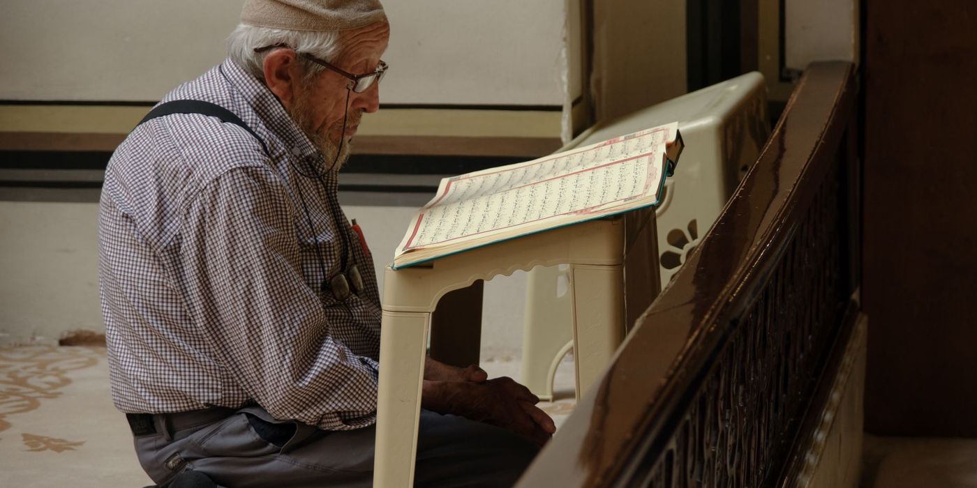 Lelaki membaca Al-Quran di masjid